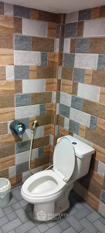 Modern bathroom with stylish tile design and functional toilet setup