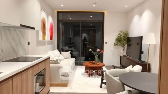 Modern living room with open kitchen, stylish decor, and cozy seating area in a contemporary apartment.