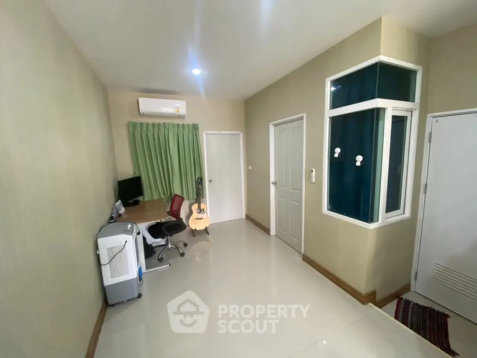 Modern study room with desk, chair, and guitar in a bright, minimalist design.