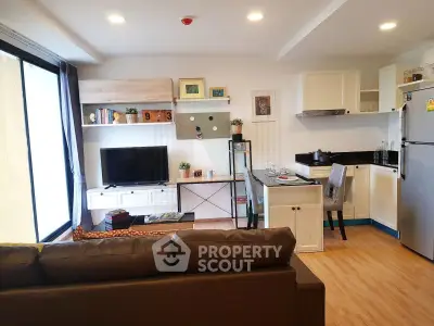 Modern open-layout living room with kitchen, featuring stylish decor and natural light.