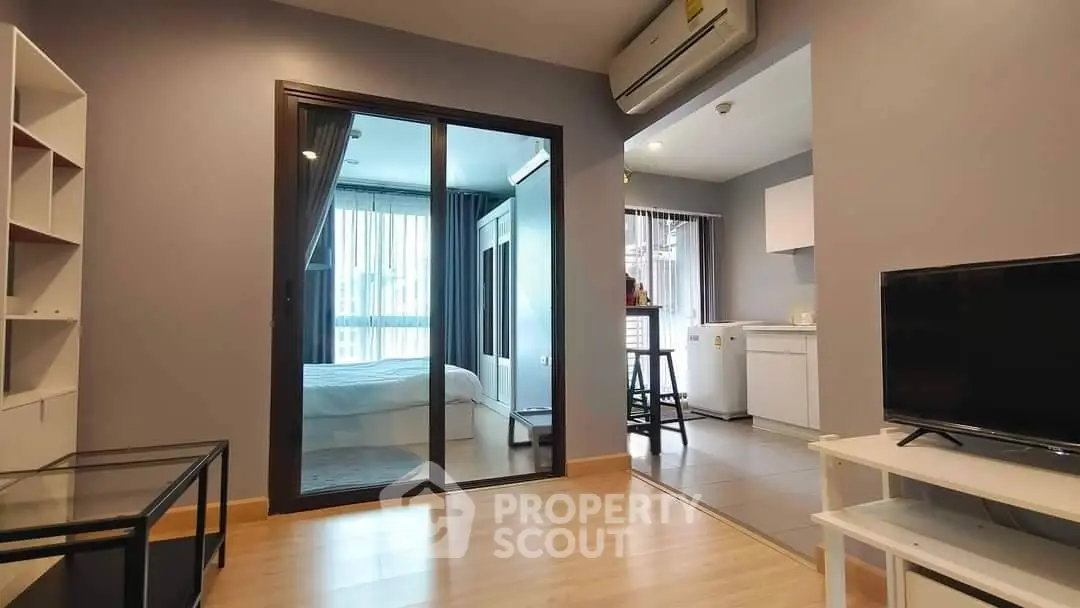 Modern apartment interior with open living area and bedroom, featuring sleek design and natural light.