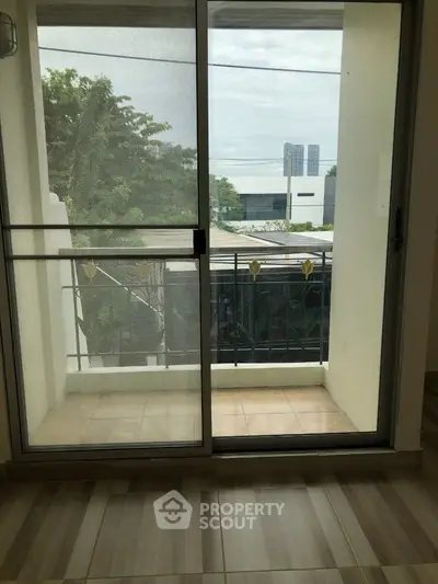 Spacious balcony with sliding glass doors and city view, perfect for relaxation.