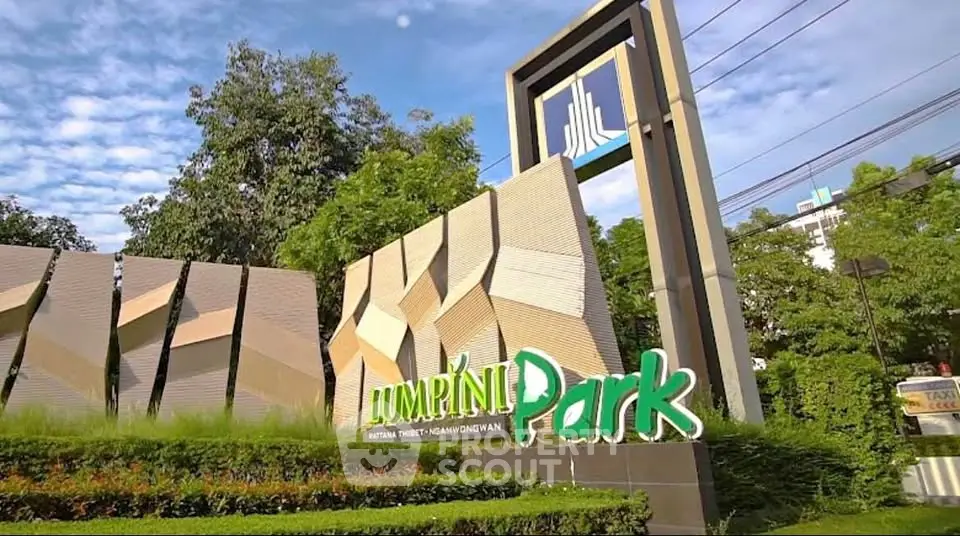 Lush entrance of Lumpini Park with modern signage and greenery.