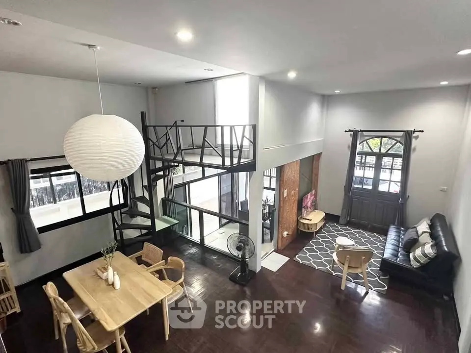 Spacious modern living room with mezzanine, stylish decor, and abundant natural light.