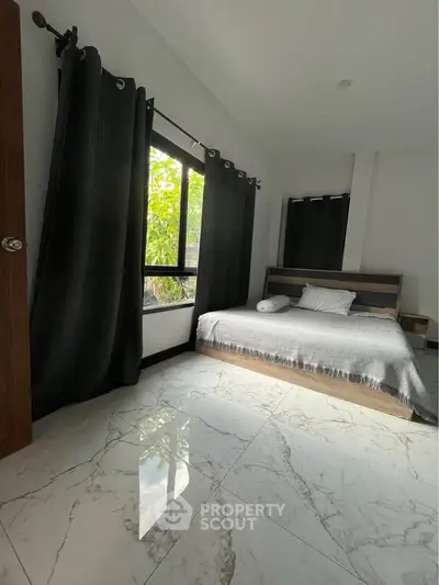 Spacious bedroom with large window and elegant marble flooring, offering a serene and modern living space.