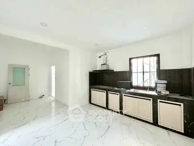 Spacious modern kitchen with sleek black countertops and marble flooring