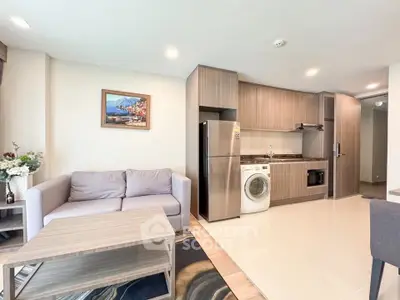 Modern open-plan living room with kitchen, featuring a washing machine and stylish decor.