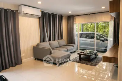 Modern living room with sleek gray sofa and large window view
