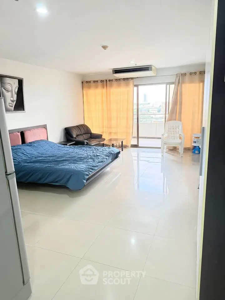 Spacious studio apartment with large windows and city view, featuring modern furnishings and ample natural light.