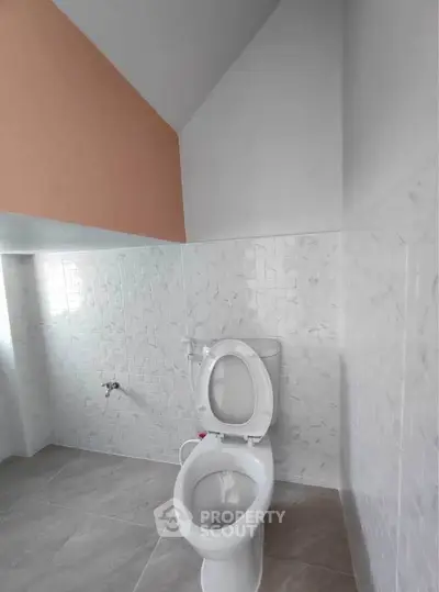 Modern bathroom with unique ceiling design and tiled walls.