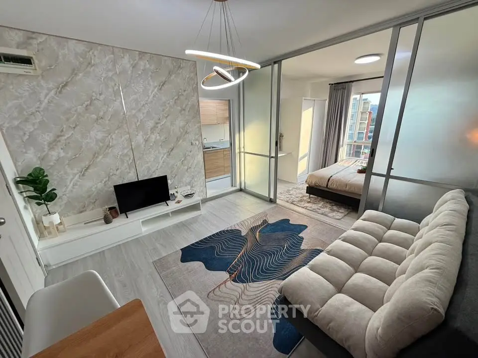 Modern open-plan living room with stylish decor and cozy bedroom view