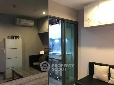 Modern apartment interior with sleek kitchen and cozy living area, featuring marble accents and stylish furniture.