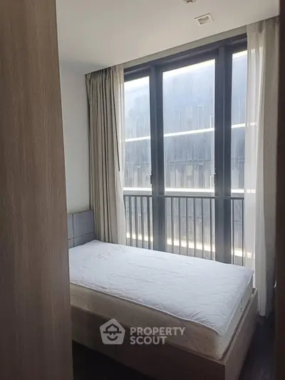 Cozy bedroom with large window and modern decor in urban apartment