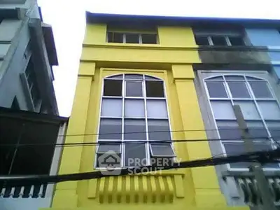 Vibrant yellow building facade with large windows in urban setting