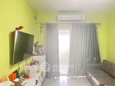 Cozy living room with bright green walls, modern sofa, and wall-mounted TV, perfect for relaxation.