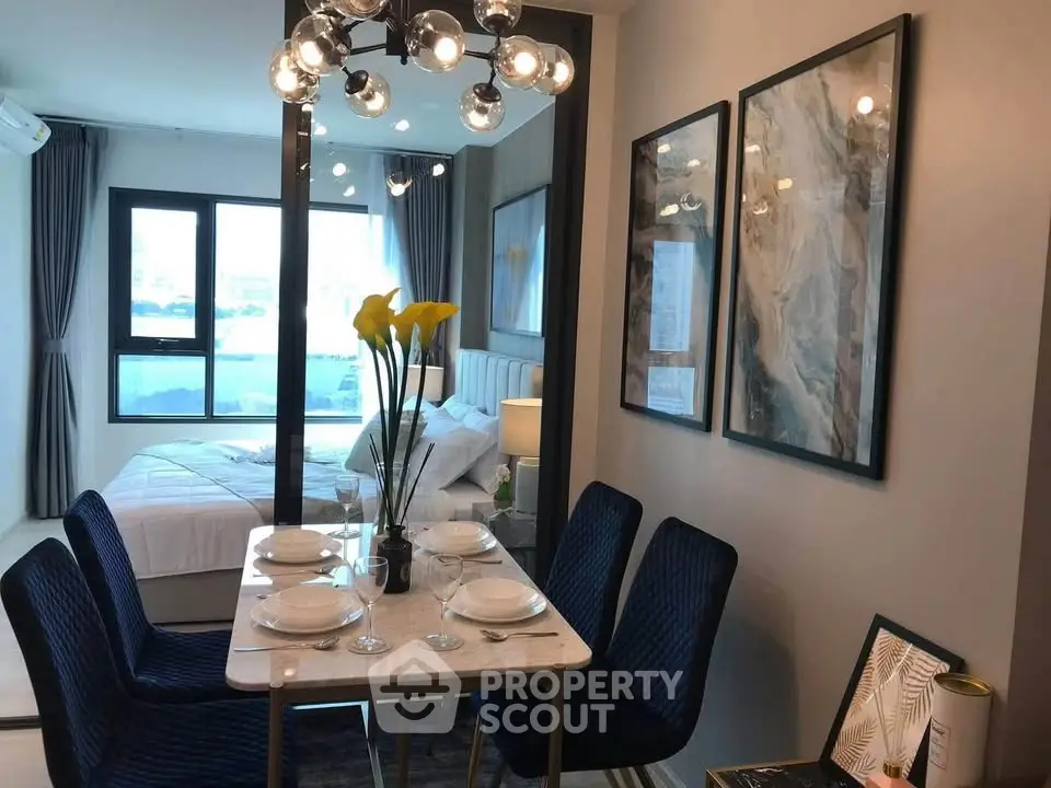 Modern dining area with elegant decor and view into a stylish bedroom, perfect for urban living.