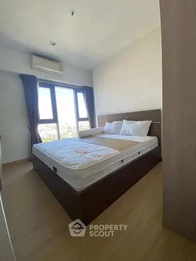 Modern bedroom with large windows and natural light in a stylish apartment.