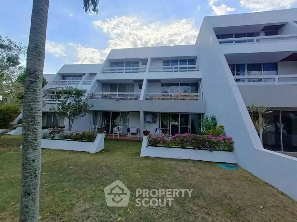 Modern multi-level building with lush garden and spacious balconies