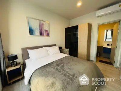 Spacious bedroom with modern decor, comfortable queen-sized bed, elegant bedding, and a sleek wooden wardrobe leading to a bright en-suite bathroom.