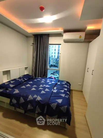 Modern bedroom with stylish lighting and city view, featuring a cozy bed and sleek wardrobe.