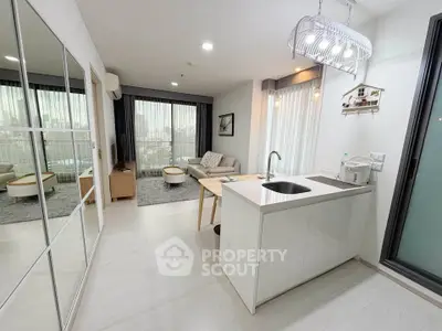 Modern open-plan living room and kitchen with sleek design and large windows.