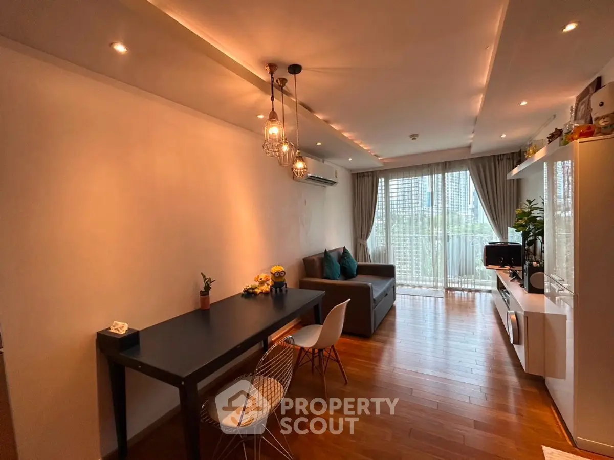 Modern living room with stylish lighting and large windows offering city views.
