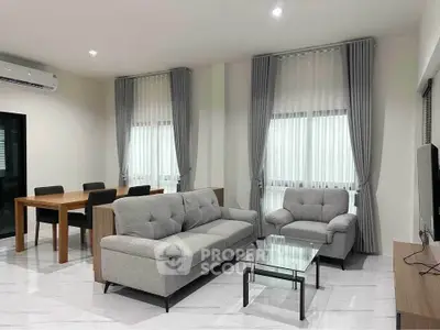 Modern living room with sleek furniture and dining area, featuring elegant curtains and bright lighting.