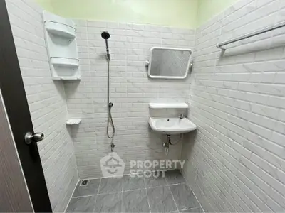Modern minimalist bathroom with white subway tiles and sleek fixtures.