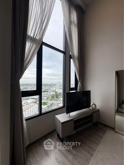 Stunning high-rise living room with floor-to-ceiling windows offering panoramic city views.