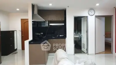 Modern kitchen with sleek cabinets and open layout in cozy apartment