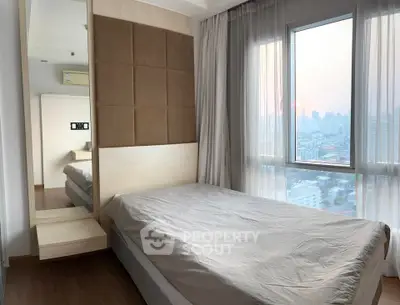Modern bedroom with city view and floor-to-ceiling windows in a high-rise apartment.