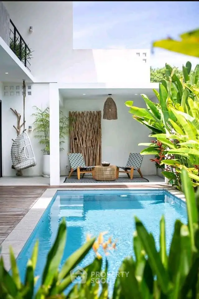 Luxurious modern poolside oasis with lush greenery and stylish outdoor seating.