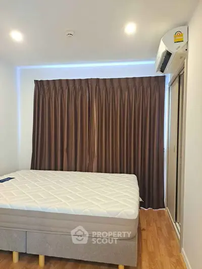 Cozy bedroom with modern air conditioning and elegant curtains, perfect for restful nights.