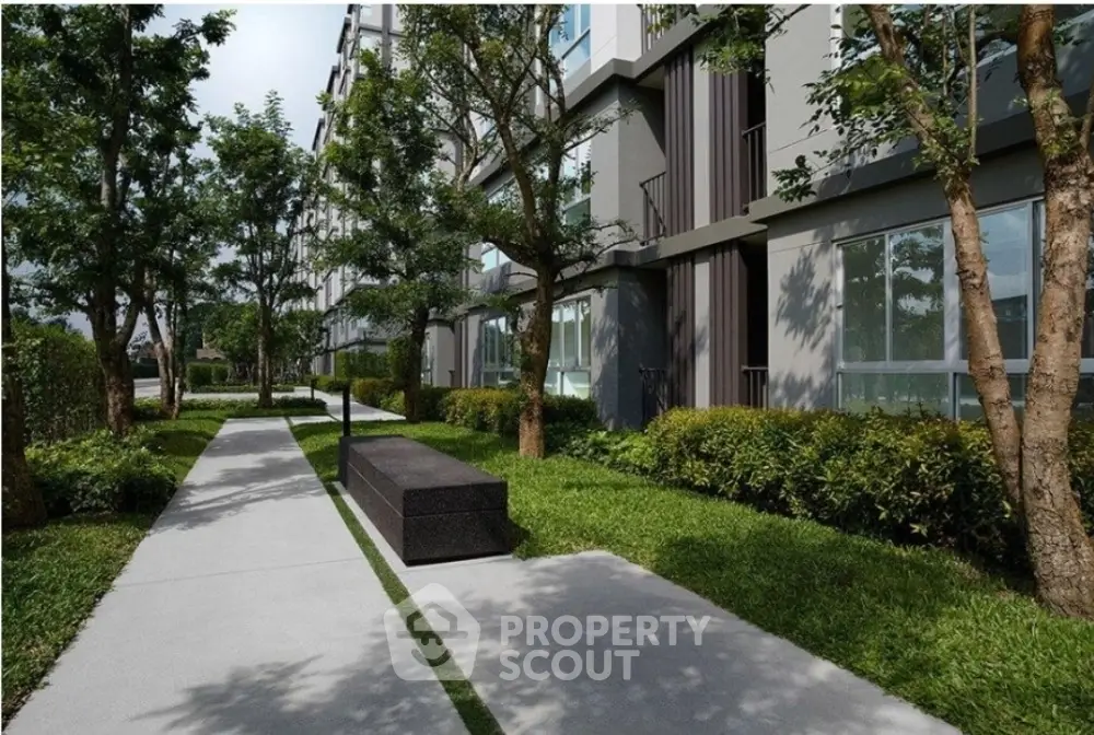 Modern apartment building exterior with lush green landscaping and walkway