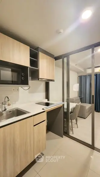 Modern open-layout kitchen with sleek cabinetry and dining area in a stylish apartment.