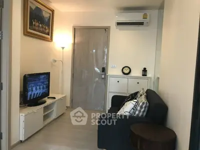 Cozy living room with modern decor, featuring a comfortable sofa, wall-mounted TV, and air conditioning.