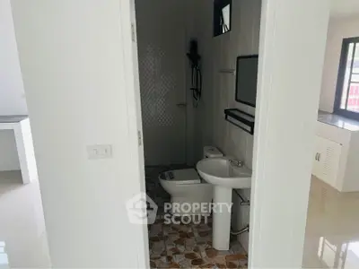 Modern bathroom with sleek fixtures and tiled floor in a bright apartment.