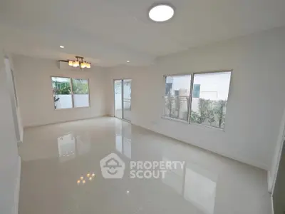 Spacious modern living room with large windows and elegant lighting.