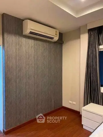 Modern bedroom with air conditioning and elegant curtains, featuring sleek wooden flooring.