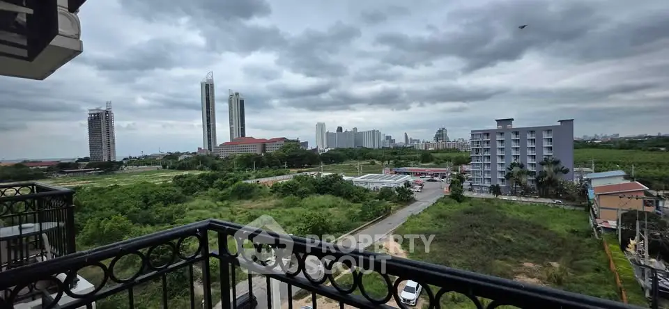 Stunning cityscape view from a balcony with lush greenery and modern skyline.