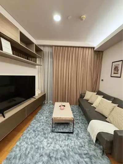 Modern living room with cozy sofa, large TV, and stylish decor