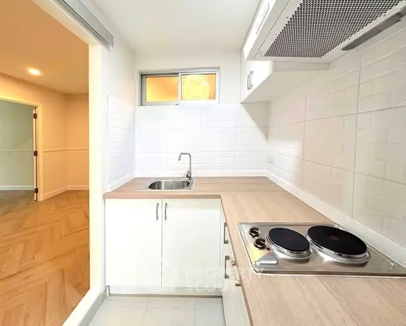 Modern kitchen with electric stove and sleek white cabinetry