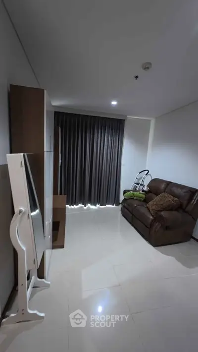 Cozy living room with modern furnishings and sleek tile flooring, perfect for relaxation.