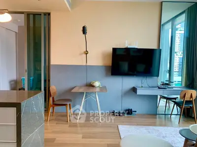 Modern living room with stylish decor and wall-mounted TV in a high-rise apartment.