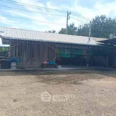 Rural property with open structure and corrugated metal roof, ideal for agricultural use.