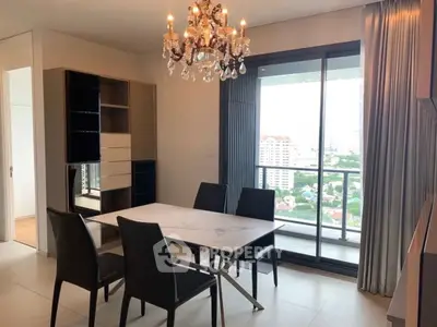 Elegant dining area with chandelier and balcony view in modern apartment