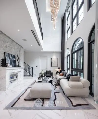 Luxurious modern living room with high ceilings, elegant chandelier, and stylish furniture in a sophisticated setting.