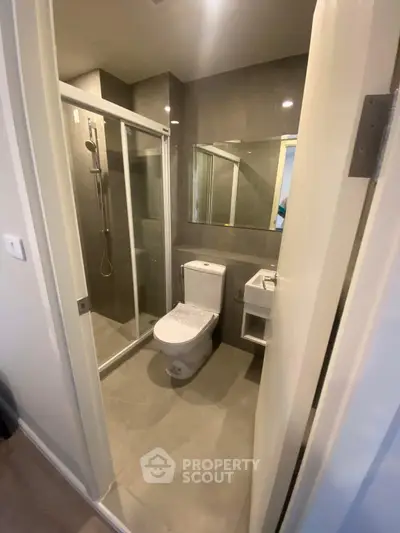 Modern bathroom with glass shower and sleek fixtures in a contemporary home.