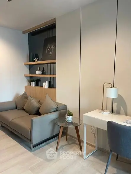 Modern living room with stylish sofa, desk, and decorative shelves in a cozy apartment.