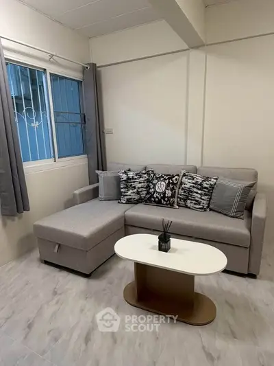 Cozy living room with modern gray sofa and stylish coffee table, perfect for relaxation and entertaining.